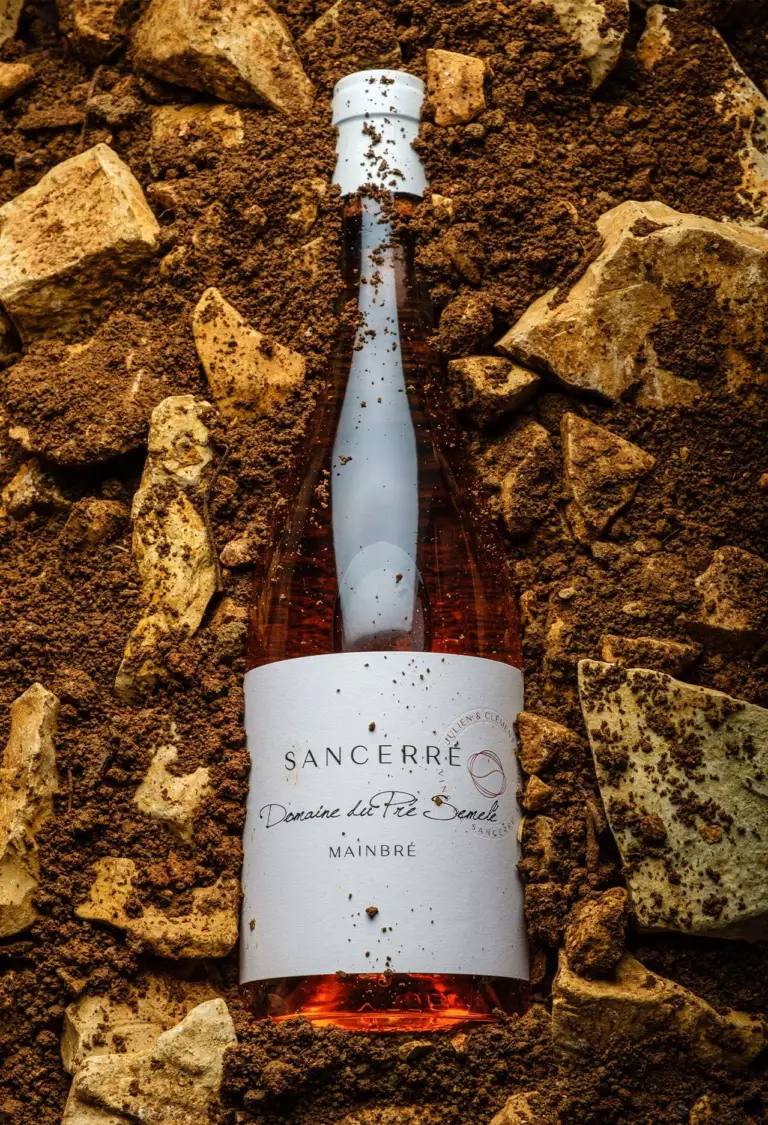 Bouteille de Mainbré Rosé posée sur le terroir du Domaine du Pré Semelé